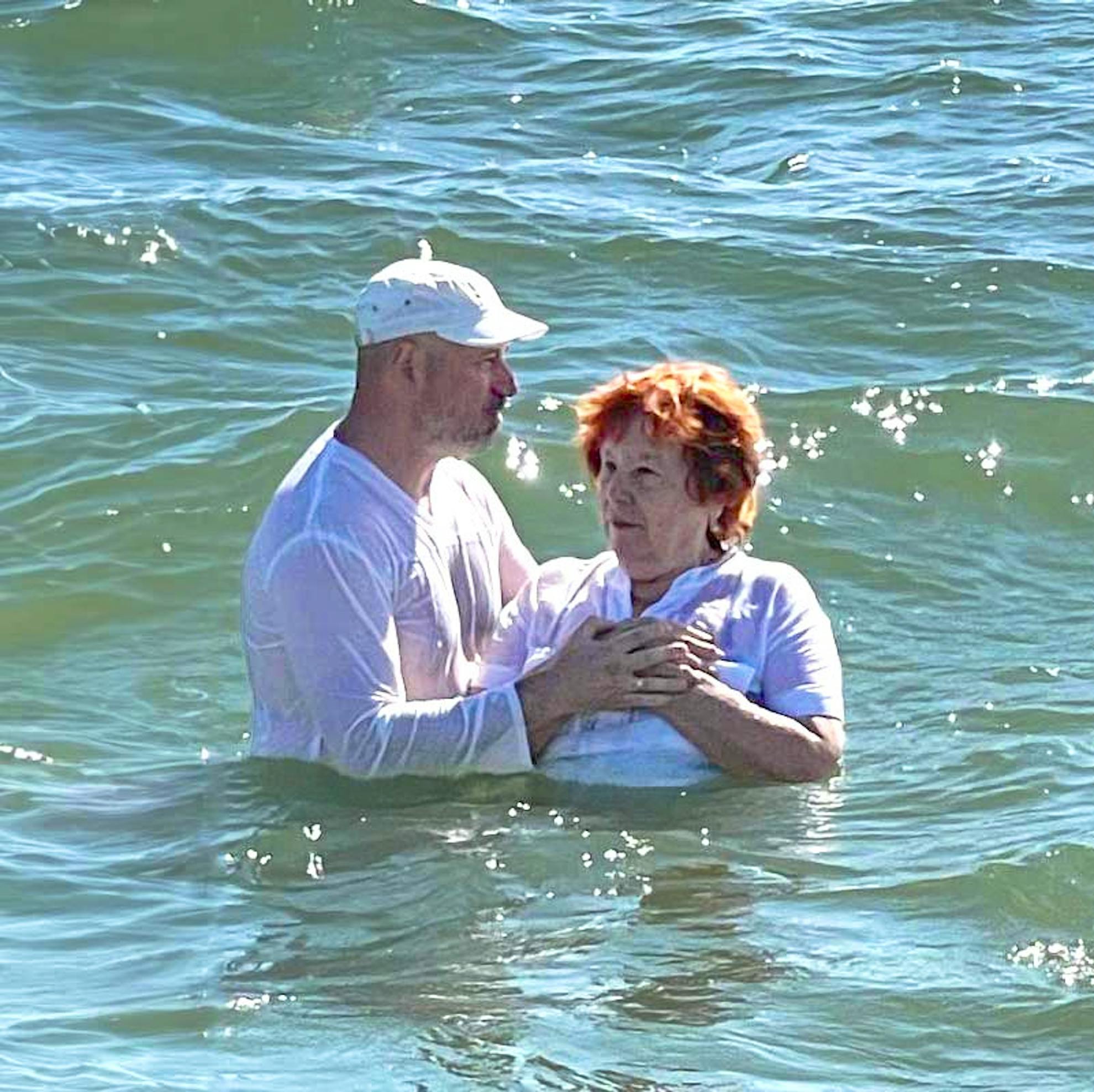 Older jewish woman beign baptized