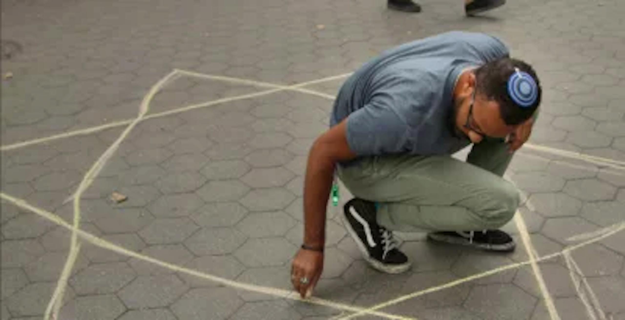 man drawing a star of david