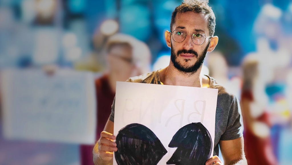 Jewish man holding sign on street