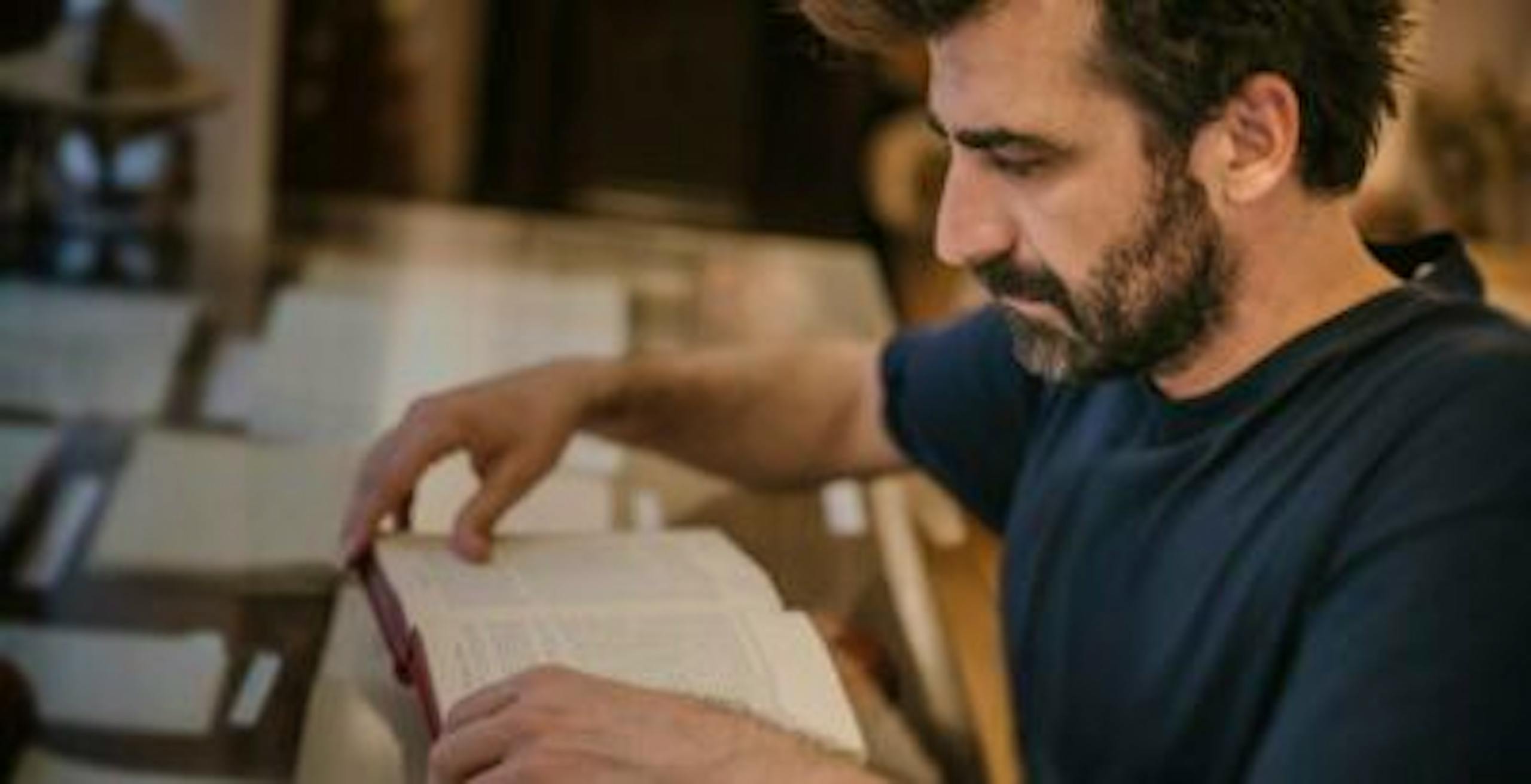 Jewish man reading the New Testament in the library