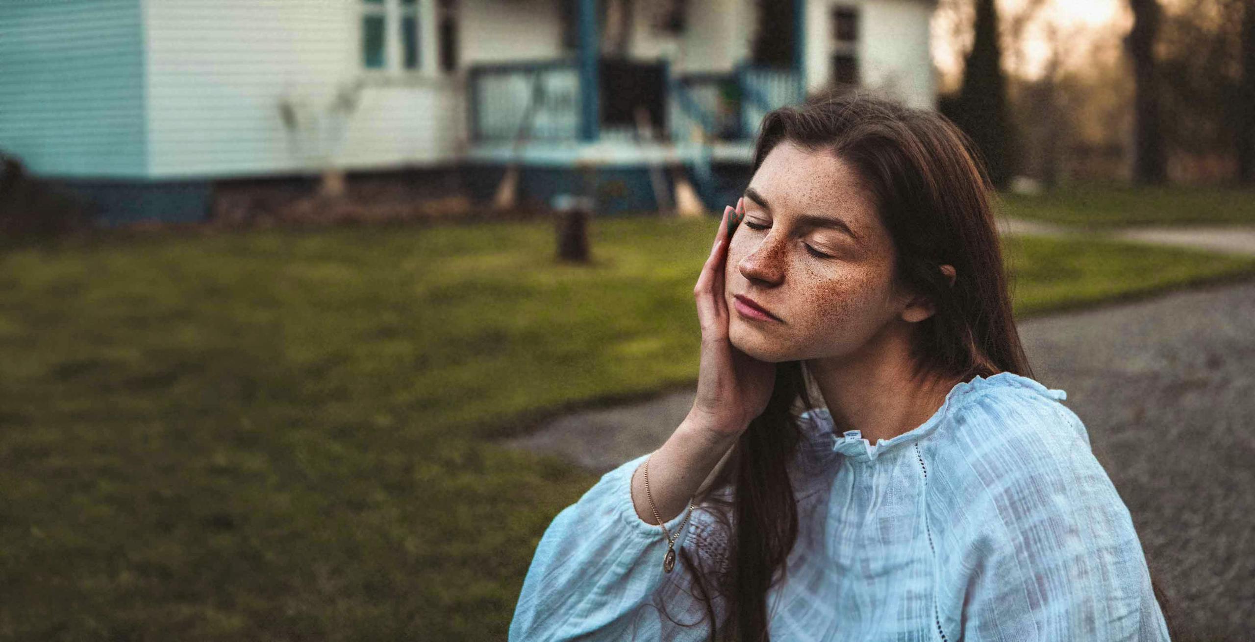 Young woman in front of house