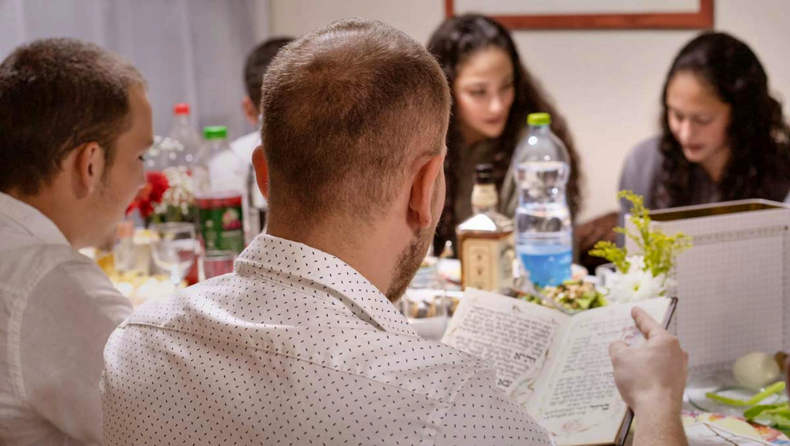 Family celebrating Passover with Haggadah