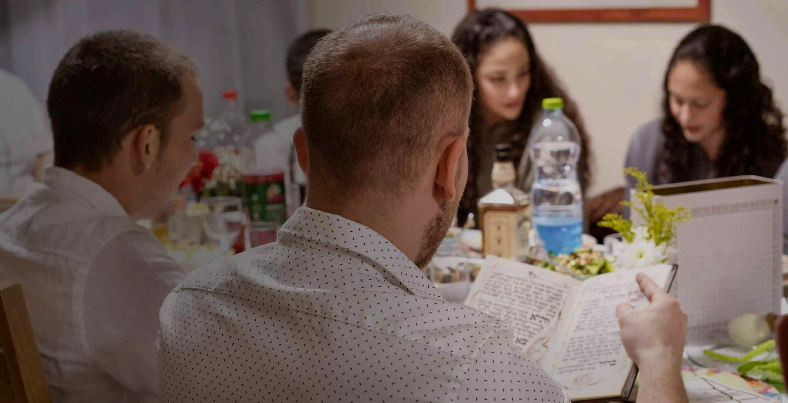 Family celebrating Passover with Haggadah