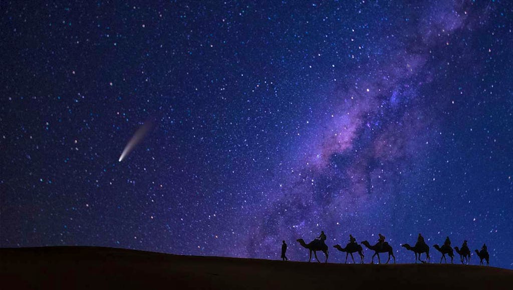 Camel procession at night with comet